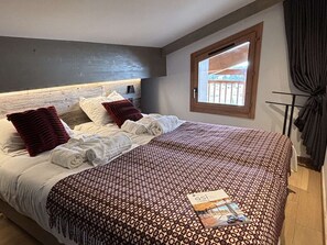 Ein Hotelzimmer mit einem großen Bett, einem Fenster mit Aussicht und einem hölzernen Kopfteil.