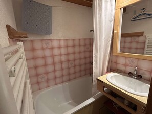 Ein Badezimmer mit einer Badewanne, einem Waschbecken und einem Spiegel.