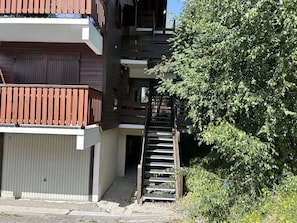 Ein mehrstöckiges Gebäude mit einer Holztreppe, die zu einem Balkon führt.