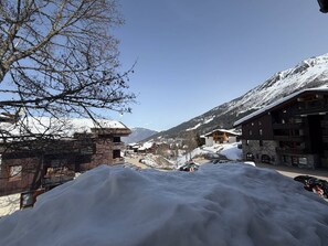 A snow-covered mountain town with buildings and a clear sky. - Cozy apartment, mountain view - 5 guests (Valmorel)