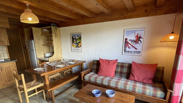 Um interior acolhedor com uma mesa de jantar de madeira, um sofá e um banco.