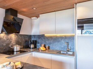 Eine moderne Küche mit Backofen, Kaffeemaschine und Spüle.