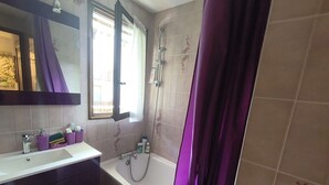 A bathroom with a bathtub, a shower, a sink, and a mirror. - Apartment with ski view balcony - 4 guests (Arâches-la-Frasse)