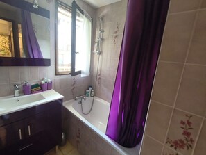 A bathroom with a bathtub, a shower, a sink, and a mirror. - Apartment with ski view balcony - 4 guests (Arâches-la-Frasse)