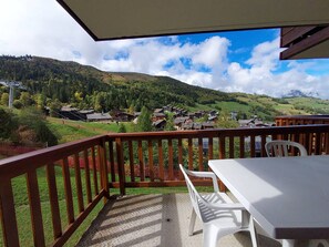 A balcony with a view of a village and hills. - Central apartment, view of slopes - 5 guests (Valmorel)