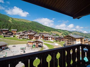 A mountain village with traditional wooden buildings, a playground, and a clear view of the surrounding hills. - Duplex with slope view - Valmorel - 6 guests (Valmorel)