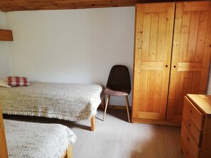 A room with a bed, a chair, a wooden wardrobe, and a dresser. - Duplex with slope view - Valmorel - 6 guests (Valmorel)