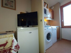 A compact kitchen with a washing machine, a microwave, and a television. - Apartment with pets allowed - Ski-in access (Valmorel)