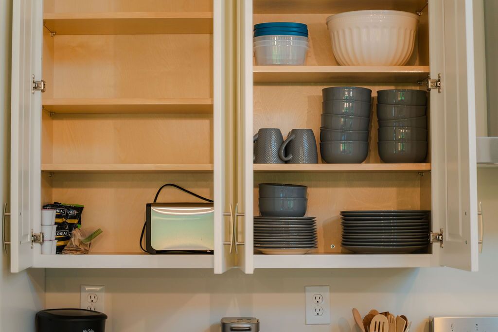 A kitchen cabinet with various dishes and utensils.