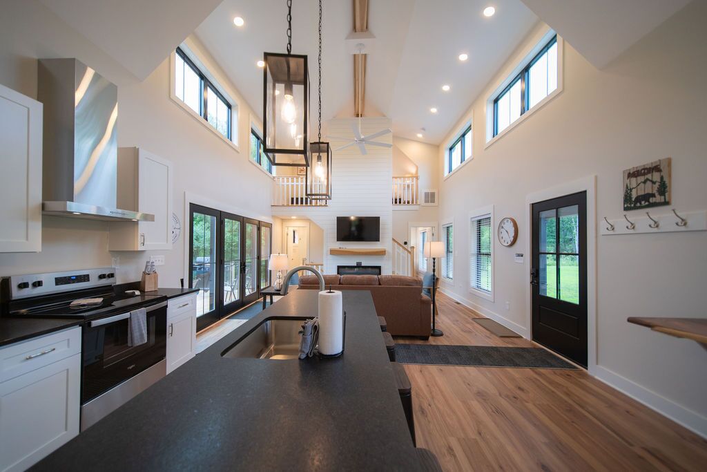 A spacious kitchen with a central island, a dining area, and a living space with a fireplace.