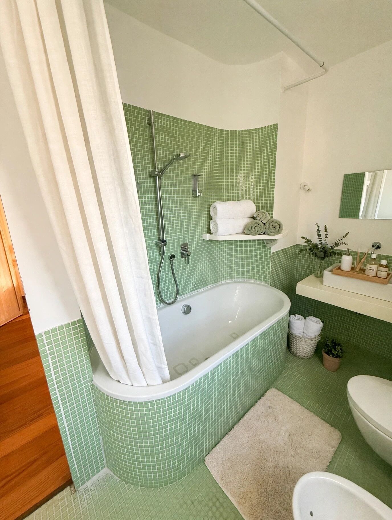 Ein Badezimmer mit freistehender Badewanne, Dusche und Waschbecken mit Spiegel.