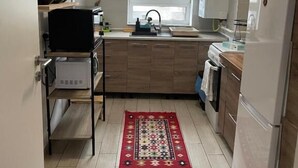 Cocina compacta con ventana, refrigerador y microondas.