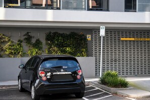 A black car parked in a parking space with a building in the background. - Hawthorn 2b charming retreat (Hawthorn)