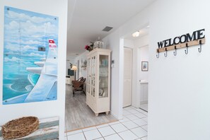 Ein Flur mit einem Willkommensschild, einer Vitrine und einem Bild eines Bootes an der Wand.