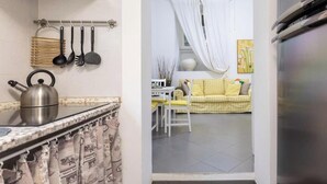A kitchen with a kettle, hanging utensils, and a curtain. - Romantic House Near the Vatican (St. Peter's Square) (Roma)