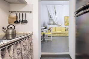 A kitchen with a kettle, hanging utensils, and a curtain. - Romantic House Near the Vatican (St. Peter's Square) (Roma)
