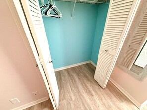 Ein kleiner Ankleideraum mit blauer Wand, Holzboden und weißer Tür.