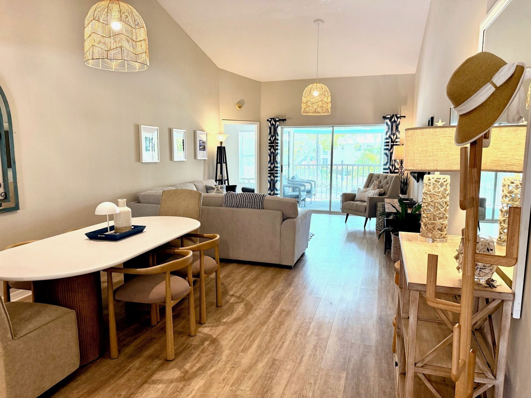 A modern living room with a dining area, large windows, and a view of the outdoors.