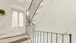 Una scala con ringhiera in metallo che porta a un pianerottolo.