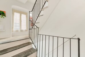 Eine Treppe mit Metallgeländer, die zu einer Zwischenebene führt.