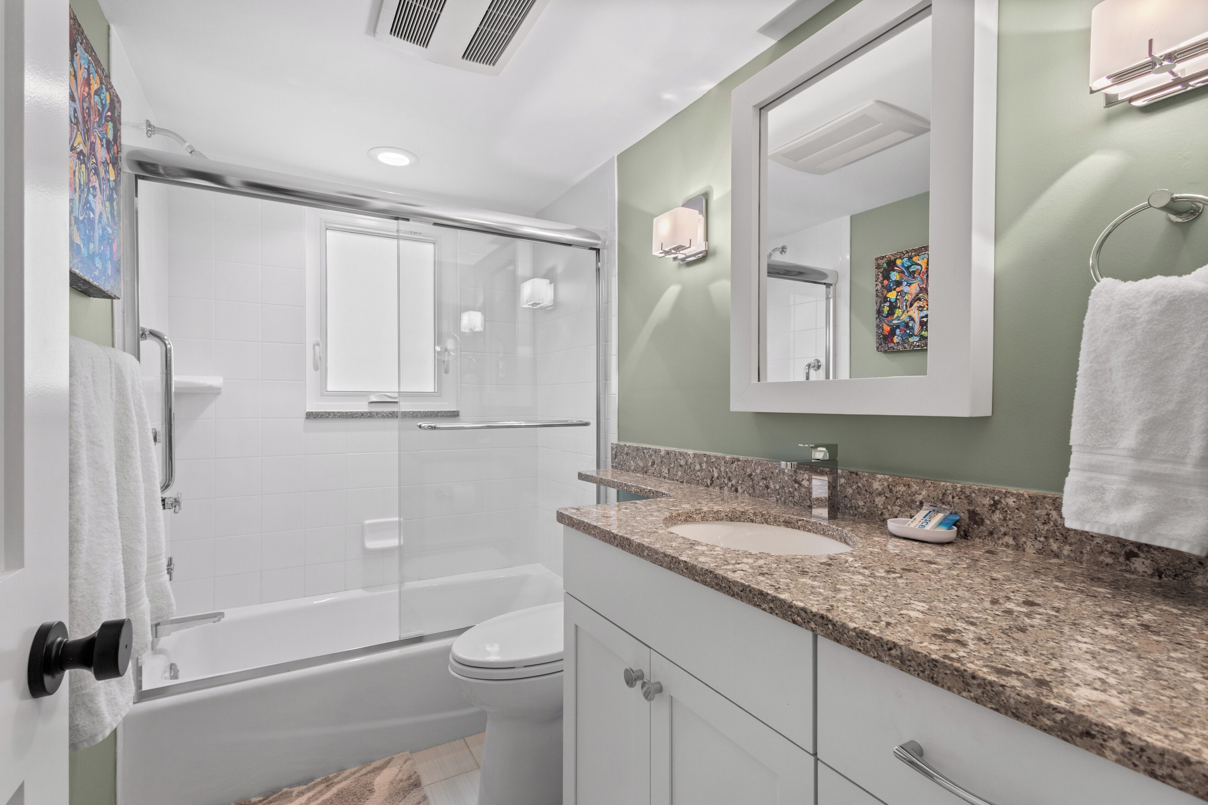 Un baño moderno con ducha, inodoro y lavamanos.