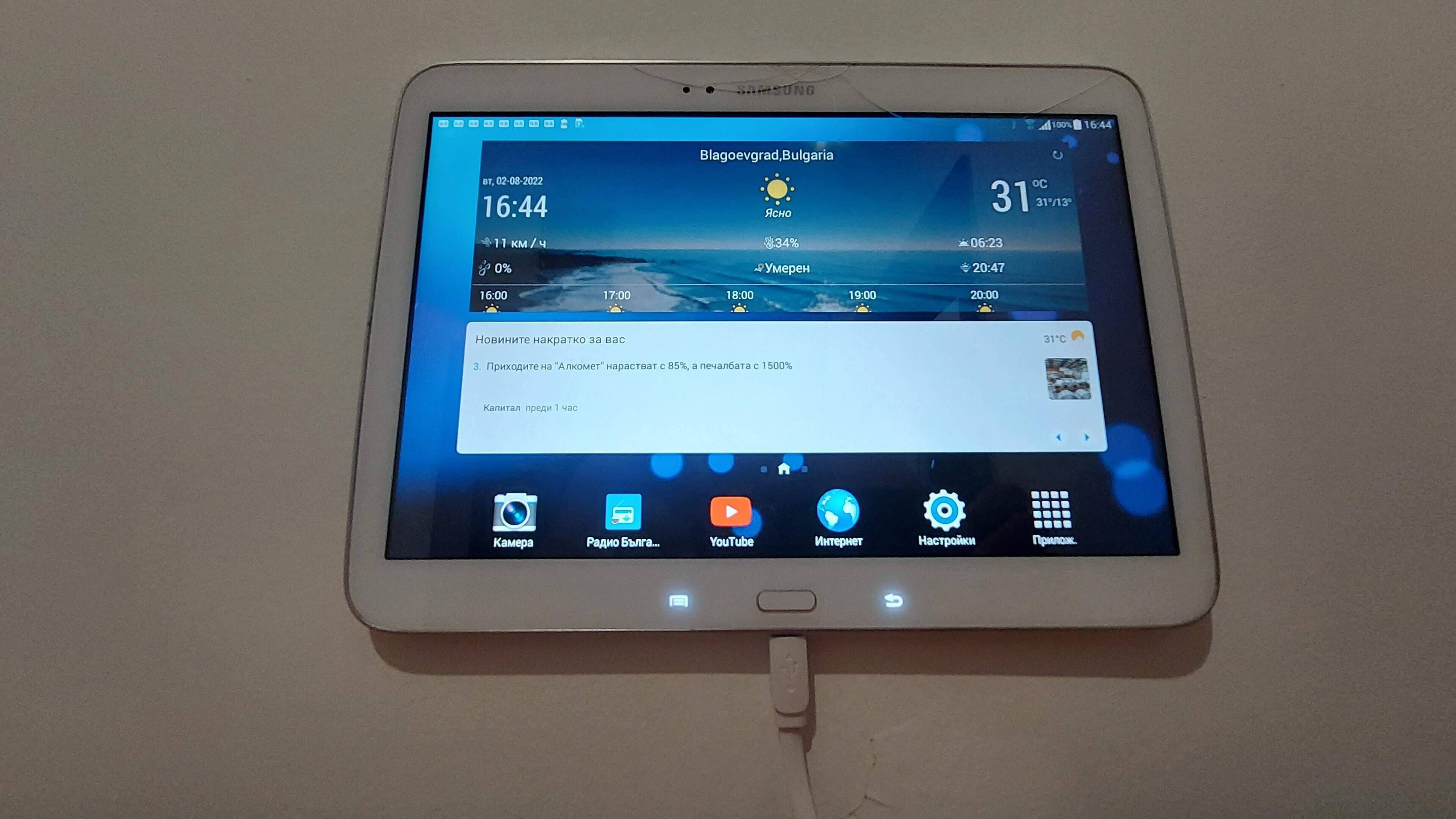 Una tauleta Samsung mostra una aplicació del temps amb un fons de platja.