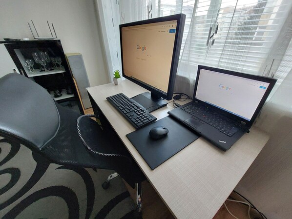 A workspace with a desk, two monitors, a keyboard, a mouse, and a chair.