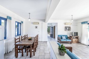 Ein modernes Interieur mit Essbereich, Wohnbereich und einer Küchenzeile.