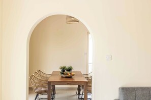 A dining area with a wooden table, wicker chairs, and a fruit bowl. - Coralia Dream 1 - Three Bedroom Villa, Sleeps 6 (Peyia)