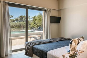 A hotel room with a bed, a TV mounted on the wall, and a view of an outdoor pool area. - Sea Melody - Two Bedroom Villa, Sleeps 4 (Ionian Islands)
