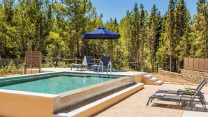 A swimming pool with lounge chairs and an umbrella, surrounded by a wooded area. - Sea Melody - Two Bedroom Villa, Sleeps 4 (Ionian Islands)