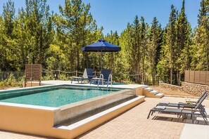 A swimming pool with lounge chairs and an umbrella, surrounded by a wooded area. - Sea Melody - Two Bedroom Villa, Sleeps 4 (Ionian Islands)
