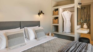 A hotel room with a bed, bedside tables, a mirror, and a wardrobe with built-in shelves. - Sea Melody - Two Bedroom Villa, Sleeps 4 (Ionian Islands)