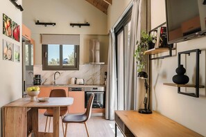 Eine kompakte Küche mit Essbereich, Backofen und großem Fenster.