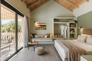 A bedroom with a large window, a bed, a seating area with a sofa, and a wardrobe. - Sea Harmony - One Bedroom Villa, Sleeps 2 (Ionian Islands)
