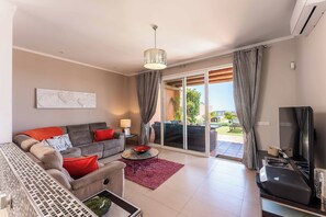 A modern living room with a sofa, coffee table, and a television. - Villa Roxiane - Three Bedroom Villa, Sleeps 6 (Adeje)