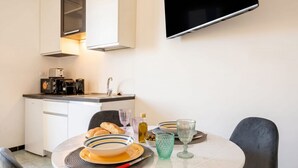 Una cocina moderna con comedor, que incluye una mesa dispuesta con platos, tazones y vasos.