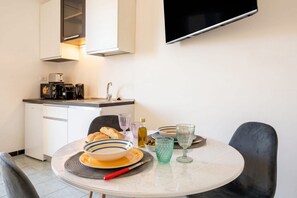 Eine moderne Küche mit Essbereich, inklusive Tisch, gedeckten Tellern, Schüsseln und Gläsern.