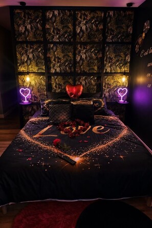 Ein Schlafzimmer mit einem Bett, einem herzförmigen Kopfkissen und dekorativer Beleuchtung.