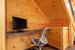 A wooden cabin interior with a desk, chair, and a television. - 🎱 Riversong Elegance | Game Room, Hot Tub & Sleeps 12, Minutes to Dollywood 🏔️ (Sevierville)
