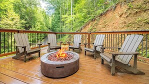 A deck with a fire pit and Adirondack chairs. - 🎱 Riversong Elegance | Game Room, Hot Tub & Sleeps 12, Minutes to Dollywood 🏔️ (Sevierville)