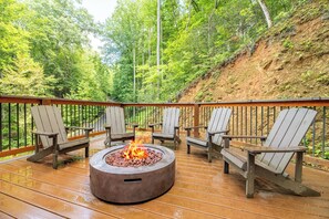 A deck with a fire pit and Adirondack chairs. - 🎱 Riversong Elegance | Game Room, Hot Tub & Sleeps 12, Minutes to Dollywood 🏔️ (Sevierville)