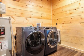 Une buanderie équipée de deux machines à laver à chargement frontal et d’un chauffe-eau.