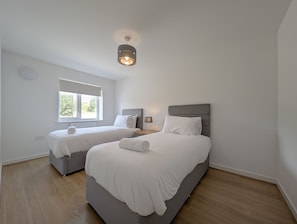 A hotel room with two beds, a window, a ceiling light, and a wooden floor. - 3-Bed Home | Sleeps 5 | Free Parking | Newcastle - Pass the Keys (Newcastle)