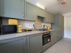 A kitchen with a microwave, stove, and cabinets. - 3-Bed Home | Sleeps 5 | Free Parking | Newcastle - Pass the Keys (Newcastle)