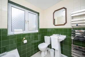 Un baño con inodoro, lavamanos y bañera.
