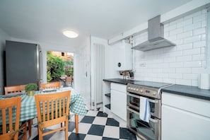 A compact kitchen with a gas stove, oven, and white tiled backsplash. - Camberwell house - with Central London bus links - Pass the Keys (London)