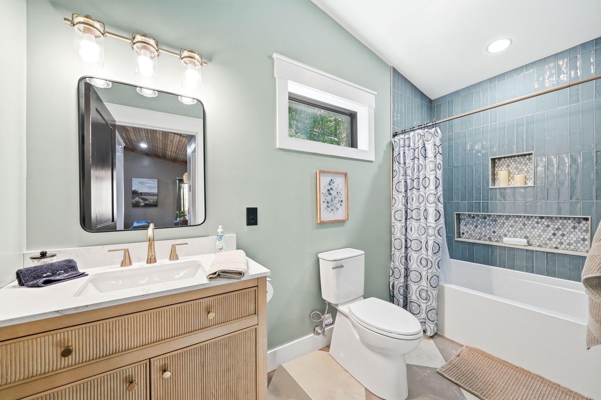 Une salle de bain équipée d’un meuble-lavabo, de toilettes, d’une baignoire et d’un rideau de douche.