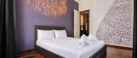 Habitación de hotel con cama, lámpara de pared, armario y pared con diseño.
