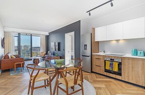 Um apartamento moderno com área de jantar, cozinha e sala de estar.
